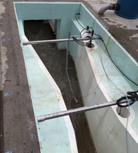 dual stilling wells on a fiberglass Parshall flume used to measure submerged flow